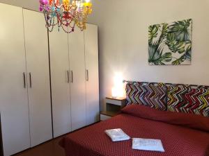 a bedroom with a red bed and a chandelier at Magnolia in Tirrenia