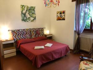 a bedroom with a red bed with two towels on it at Magnolia in Tirrenia