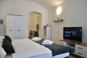 a bedroom with a large bed and a flat screen tv at White Swan Boutique Apartments in Prague