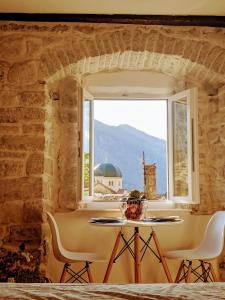 a table and chairs in a room with a window at Romantic Rooftop View Hideaway- Old Town Nr 404 in Kotor