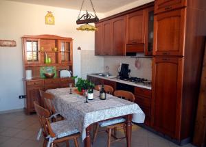 a kitchen with a table with chairs and a kitchen with wooden cabinets at Casa di lu mari in Tre Fontane