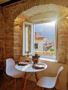 コトルにあるRomantic Rooftop View Hideaway- Old Town Nr 404の窓の前のテーブルと椅子 +17枚の写真