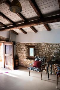 a living room with a chair and a stone wall at Il giardino dei mandorli Agriturismo in Alatri