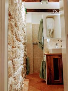 a bathroom with a sink and a stone wall at Romantic Rooftop View Hideaway- Old Town Nr 404 in Kotor