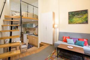 ein Wohnzimmer mit einem Sofa und einem Tisch sowie eine Küche in der Unterkunft Supercute mini house in the center in Krakau