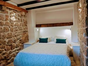 a bedroom with a bed in a stone wall at Romantic Rooftop View Hideaway- Old Town Nr 404 in Kotor