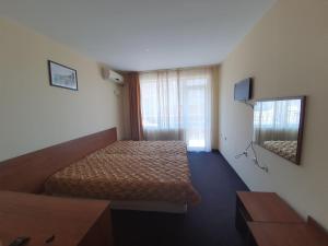 a hotel room with a bed and a mirror at Sandor Hotel in Nesebar