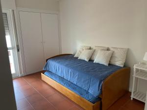 a bedroom with a bed with blue sheets and pillows at Soltroia Housefeelings in Troia