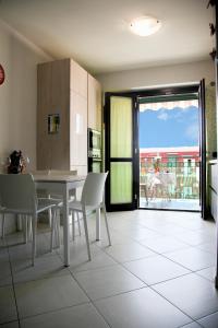 cocina con mesa y sillas y balcón en Luca Quaranta Apartment, en Nápoles