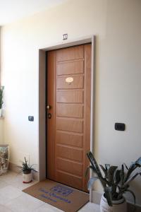 una puerta de madera en una habitación con una maceta en Luca Quaranta Apartment, en Nápoles