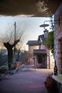 a patio with a tree and a bench and a building at Il giardino dei mandorli Agriturismo in Alatri