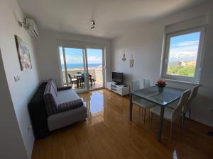 a living room with a table and a dining room at Apartment Emmy in Novalja