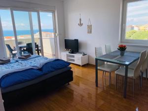 a bedroom with a table and a dining room with a view at Apartment Emmy in Novalja