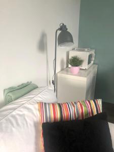 1 dormitorio con 1 cama con microondas y silla en Le studio de la Villa Madeleine, en Spa