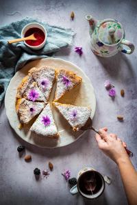 a person cutting a piece of cake on a plate at Il giardino dei mandorli Agriturismo in Alatri