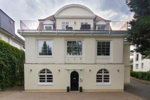 ein großes weißes Haus mit Balkon darüber in der Unterkunft Die Villa in Mannheim