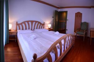 una camera da letto con un grande letto con lenzuola bianche di Appartamenti Astoria La Villa a La Villa