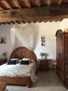 una camera da letto con un letto grande con testiera in legno di Podere La Castellina a Podere Poggiaccio