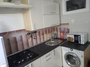 a small kitchen with a sink and a microwave at Уютная квартира у самого моря, пляж, парк in Chornomorsk +4 photos