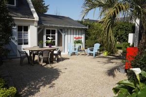 una casa y un patio con mesa y sillas en L'écrin de l'Océan, 80 mètres de la mer., en Le Pouliguen
