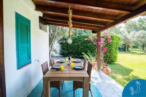 patio con tavolo in legno e sedie. di Villa Turchese - Exclusive dimora on the beach a Geremèas