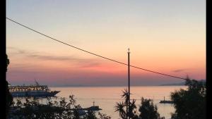 a large ship on the water at sunset at Rania Apartments Sea View in Mikonos