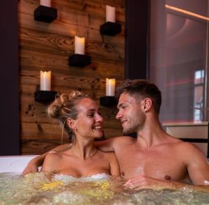 a man and a woman sitting in a bathtub at Spa Villa Beauty & Wellness Resort in Wingerode