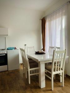 a white table and chairs in a kitchen with a window at Art Resort in Peje