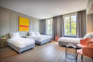 une chambre d'hôtel avec deux lits et un canapé dans l'établissement Hotel Augustyn Brugge, à Bruges