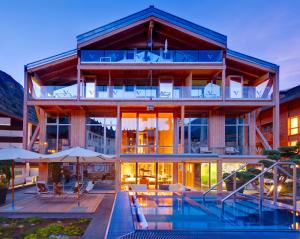 a building with a pool in front of it at Backstage Boutique SPA Hotel in Zermatt