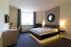 a bedroom with a bed and a desk and a window at Die Villa in Mannheim