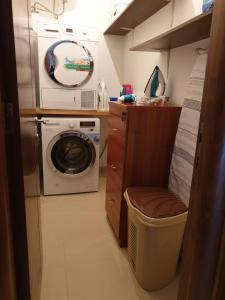 een kleine badkamer met een wasmachine en een spiegel bij Feel's Like Home at Telma Maisonette in St Paul's Bay
