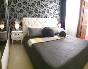 - une chambre avec un grand lit et une tête de lit blanche dans l'établissement Feel's Like Home at Telma Maisonette, à San Pawl il-Baħar