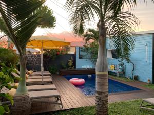 聖彼得的住宿－Maison d'hôtes Côté Lagon，一个带躺椅的游泳池,并种植了棕榈树