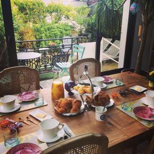 a table with food on it with a view of a balcony at L'écrin de l'Océan, 80 mètres de la mer. in Le Pouliguen