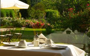 a table with plates and utensils and an umbrella at VILLA PRATO in Sperlonga
