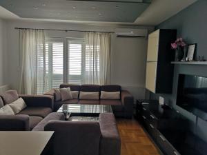 een woonkamer met een bank en een tv bij Apartment SeaSun in Makarska