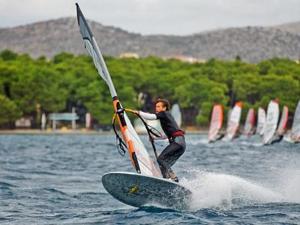 a man is on a surfboard in the water at APARTMENT TONY - 2bdr Beachfront in Jadrija