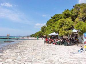 a group of people sitting at tables on a beach at APARTMENT TONY - 2bdr Beachfront in Jadrija