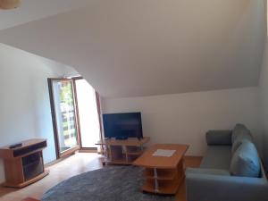 a living room with a couch and a tv and a table at TIC Hervartov in Hervartov