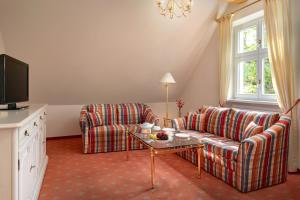 a living room with two couches and a tv at Klosterhof St. Salvator in Bad Griesbach