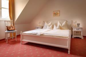 1 dormitorio con 1 cama blanca, 2 mesas y ventana en Klosterhof St. Salvator en Bad Griesbach