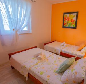 a bedroom with two twin beds and a window at APARTMENT TONY - 2bdr Beachfront in Jadrija