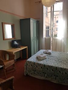 a bedroom with a bed and a desk and a television at Albergo Lungomare in Bonassola