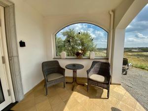 Zimmer mit 2 Stühlen, einem Tisch und einem Fenster in der Unterkunft Dune Apartment in Zandvoort