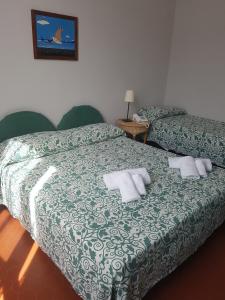 a bedroom with two beds with white pillows on it at Albergo Lungomare in Bonassola