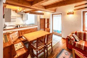 een keuken en eetkamer met een houten tafel bij Appartamento Casa Brigadoi in Predazzo +26 foto's