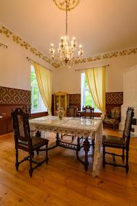 a dining room with a table and chairs and a chandelier at Admirala nams in Liepāja