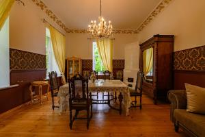 a dining room with a table and chairs at Admirala nams in Liepāja