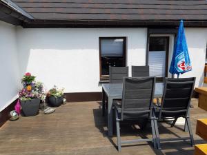 eine Terrasse mit einem Tisch, Stühlen und einer Flagge in der Unterkunft Familienfreundliche Ferienwohnung in Zschorlau